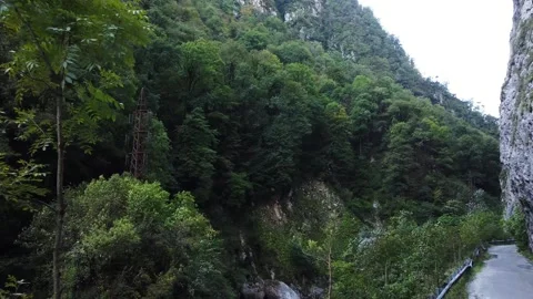 An old highway in the mountains and a mountain river. The view from the drone. Stock Footage 220574587
