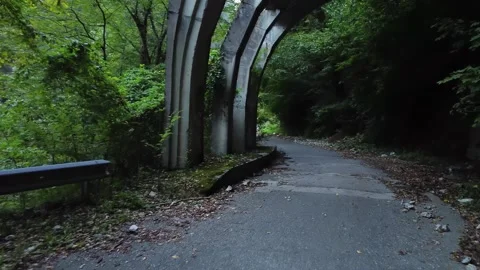 An old highway in the mountains and a mountain river. The view from the drone. Stock Footage 220574773