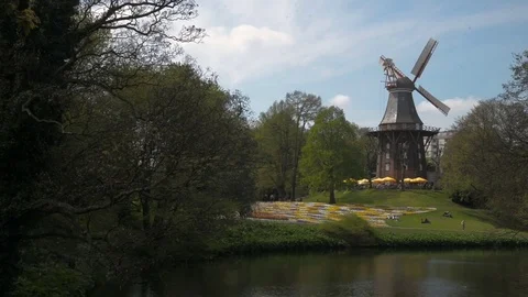 Old historic windmill at Bremen with sky and colorful flowers in front. Mill Stock Footage 79414009