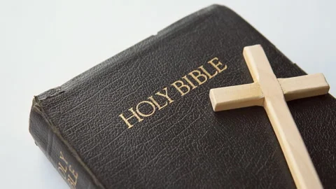 Old Holy Bible with a cross on the table. Close up. Stock Footage 236358693