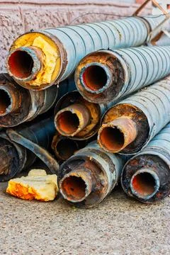 Old hot water pipes in stack near wall covered with foam insulation Old ho... Foto stock