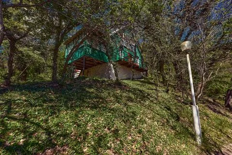 Old house in the branches of trees during the day Stock Photos