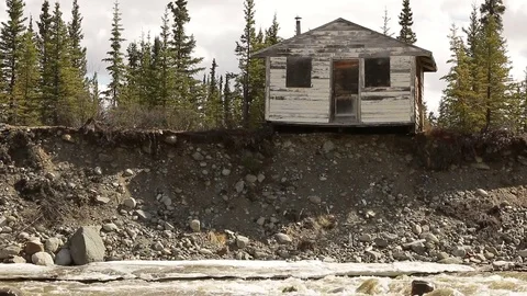 Old house cabin on cliff edge above river Stock Footage 79079348