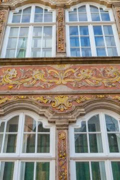 Old house facade with windows decorated with painting and gold monograms. German Stock Photos