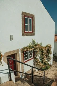 Old house with flowered window in cobblestone alley with steps Stock Photos