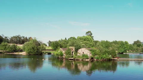 Old house in the middle of the river full of greenery in a beautiful sunny day Video stock 280123152