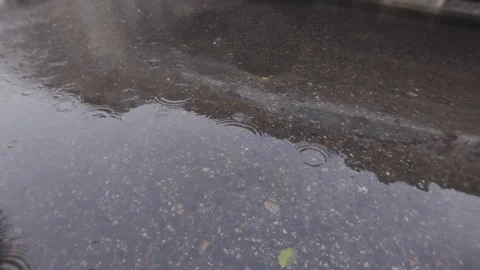 An old house is reflected in puddle on asphalt, cars rush along road, raindrops Stock Footage 339371079