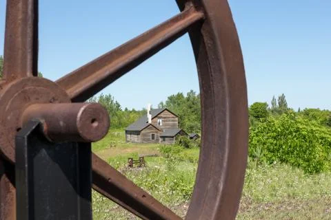 Old House Viewed Through a Rusty Wheel Stock Photos