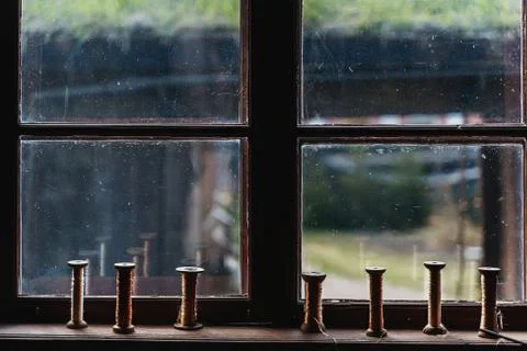 An old house with a window on which there are threads for yarn Stock Photos