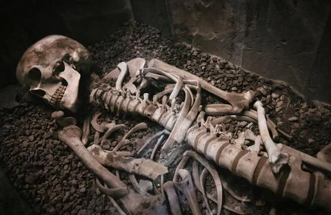 An old human skeleton lying in a stone coffin or sarcophagus Stock Photos