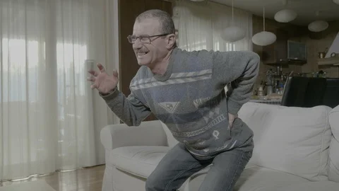 Old ill man suffering from lumber issue unable standing up holding his painfu Stock Footage 88401336