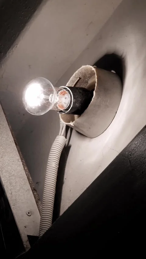 Old Incandescent Light Bulb Flickering in a Damaged Socket Stock Footage 325224105