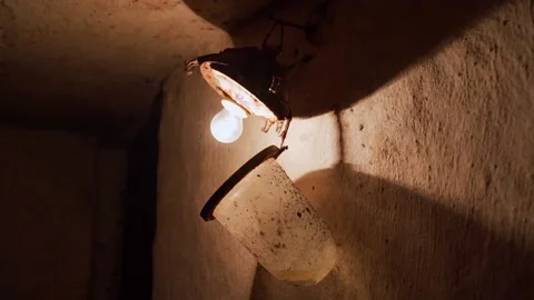 An old incandescent light bulb in an old lampshade with a glass cover in an Stock Footage 187607906