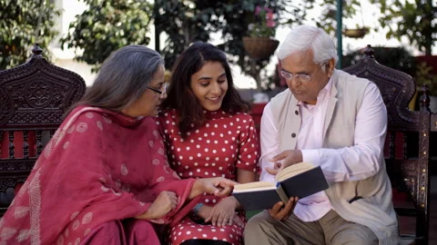An old Indian man reading a book with his wife and daughter - a happy family,... Video stock 242090924
