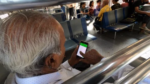 Old Indian man on smartphone in train. Mumbai, India. Stock Footage 129078740
