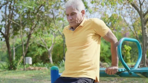 Old Indian man working out on outdoor gym equipment during morning daylight. Stock-Footage 247999622