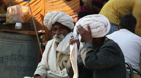 Old indian man wraps the fabric produced as a traditional turban Stock Footage 61369177