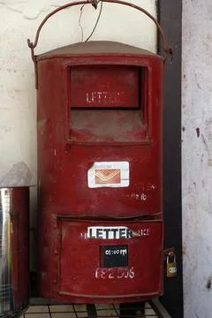 An old Indian red  post box hanging on a wall in kerala Foto stock
