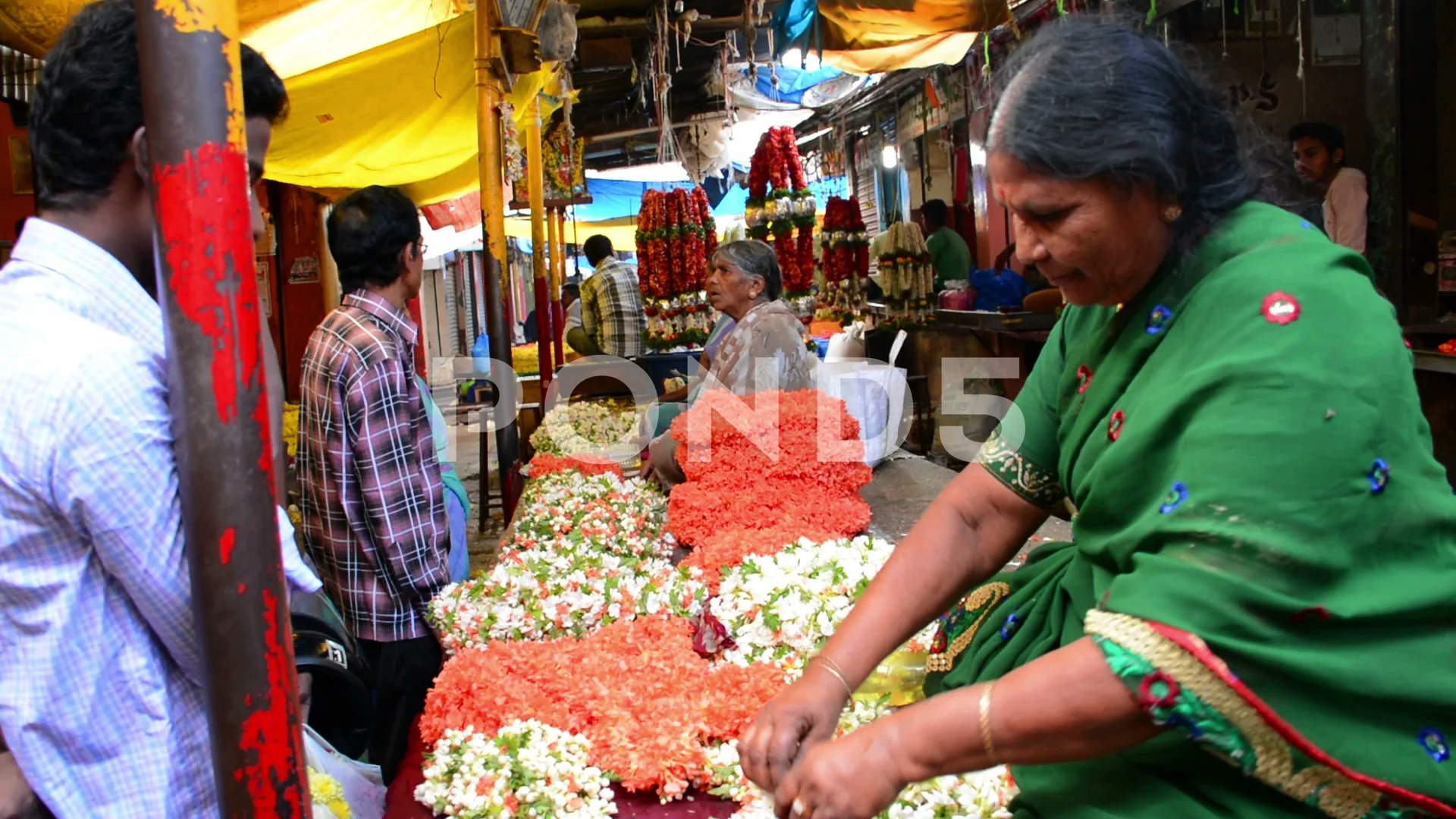 Indian elderly woman selling flowers in an old market of P…