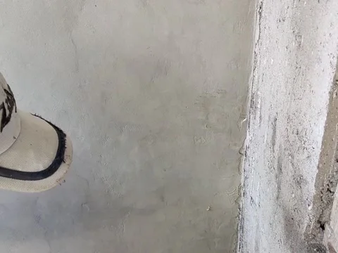 An old Indonesian builder is plastering a wall using traditional tool Stock Footage 197706777