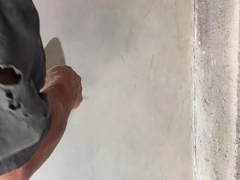 An old Indonesian builder is plastering a wall using traditional tool Stock Footage 197706846