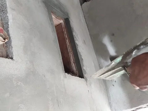 An old Indonesian builder is plastering a wall ventilator using traditional tool Stock Footage 197707123