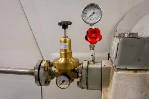 An old industrial manually adjustable pressure regulator Stock Photos