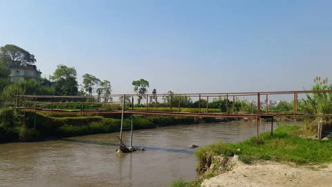 Old iron bridge made by local people in a river Stock Footage 248734434