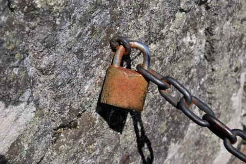 Old iron chain fixed to stone wall Stock Photos