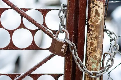 The old iron gate is locked with a chain. Breaking and entering private prope Stock Photos