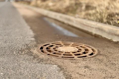 A old iron hatch with a pattern above an observation well is located on auto Stock Photos