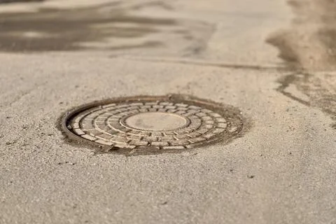 A old iron hatch with a pattern above an observation well is located on auto Stock Photos