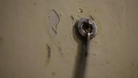 The old iron key from the house hangs on the wall on the nail Video stock 93849254
