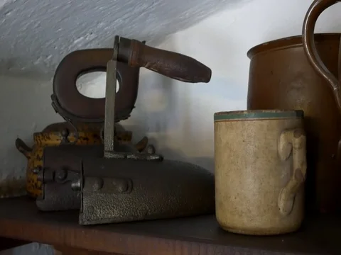 Old iron on wooden shelf. Antique flatiron. Stock Footage