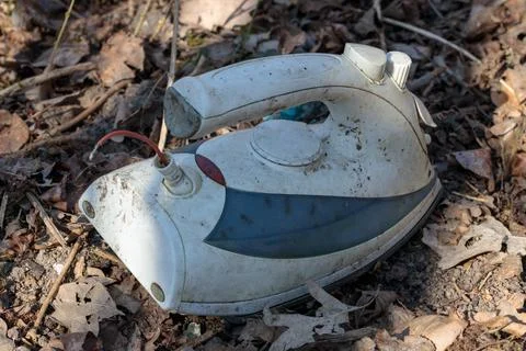Old ironing iron, abandoned. The problem with electro-waste. Illegal dump. Stock Photos
