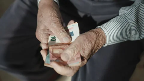 Old Italian pensioner holding stack of euro banknotes in his wrinkled hands Stock-Footage 168256652
