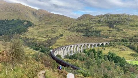 Old Jacobite steam train passes over the Glenfinnan Viaduct, Scotland. Stock Footage 243848776