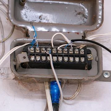 An old junction box with wires on a light wall Fotos Stock