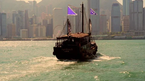 Old junk boat sails across the beautiful Hong Kong harbor Stock Footage 99338644
