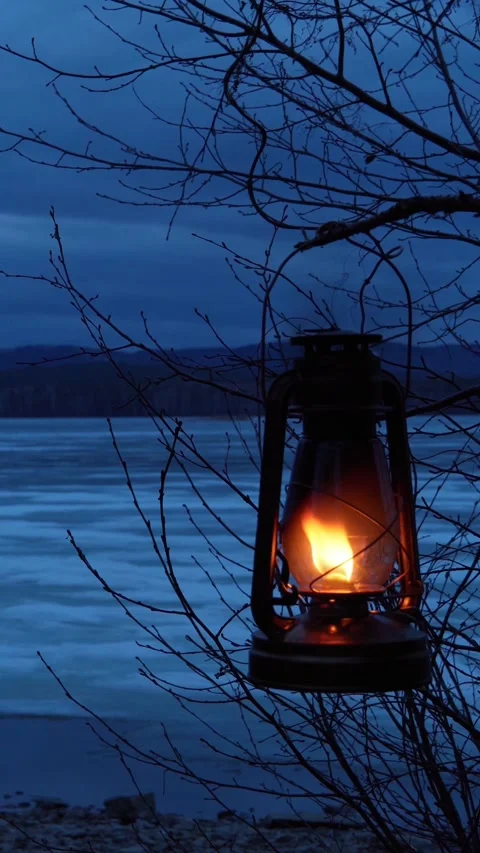 An old kerosene lamp hangs on a tree and burns with an orange flame. Stock Footage 273672757