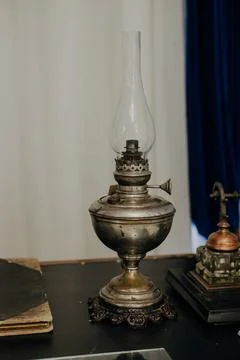 Old kerosene lamp on a rustic table. Vintage writing desk Stock Photos