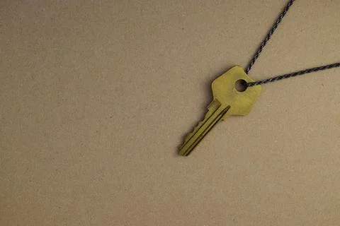 Old key on a chain on a brown background Stock Photos