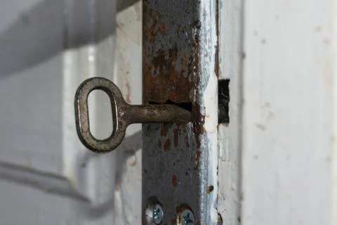 Old key in the door lock closeup. Stock Photos