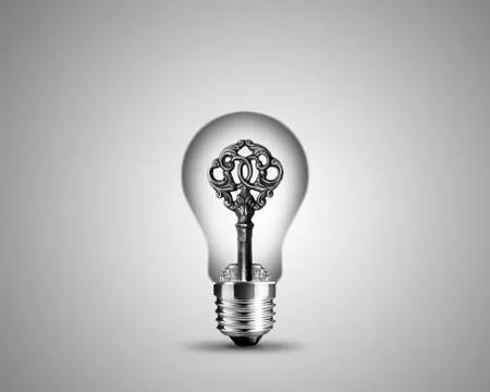 Old key in light bulb Stock Photos