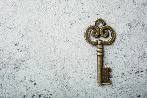 Old key on old gray concrete background. Fotos de archivo