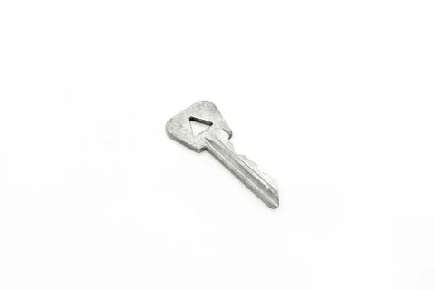 Old key with a triangular hole on white background Foto stock