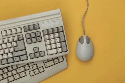 Old keyboard and pc mouse on yellow background. Top view. Flat lay 스톡 사진