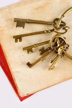 Old keys on old book Stock Photos