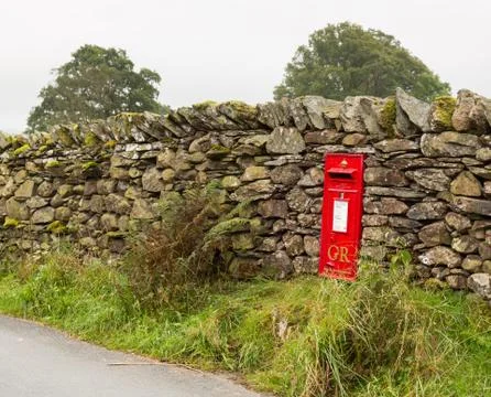 Old king george red post box in stone wall Stock Photos