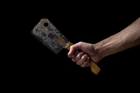 Old kitchen hatchet on a black background. A man's hand holds a kitchen hatchet. Stock Photos